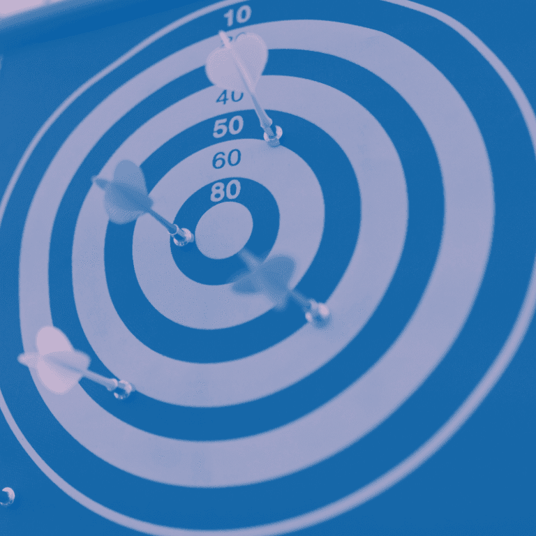 blue gray toned dartboard with darts in various places